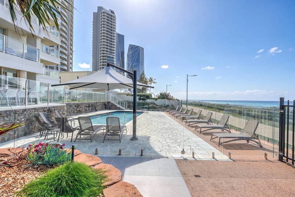 Viscount outdoor pool surrounded by loungers, shade umbrella and gardens